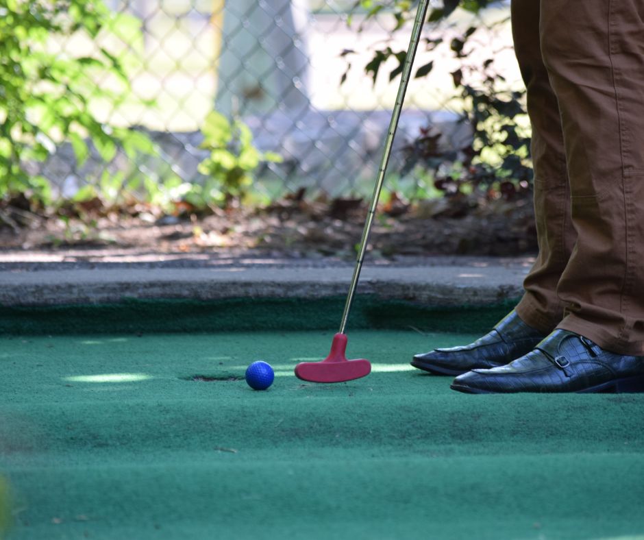 A person playing mini golf.