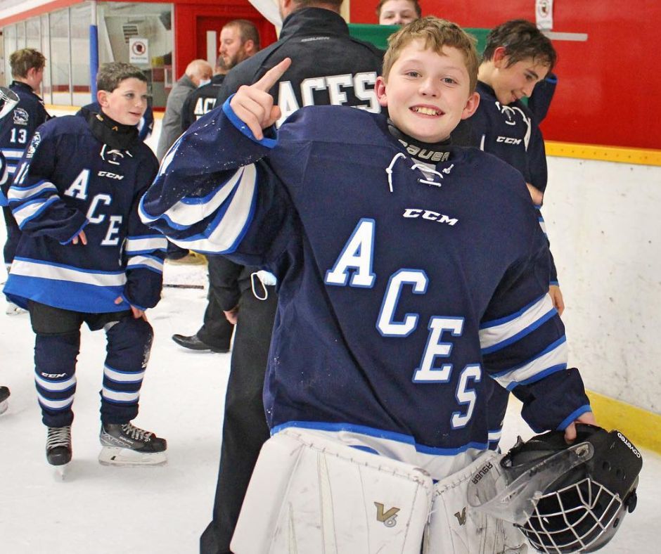 A young hockey player celebrates after a victory.