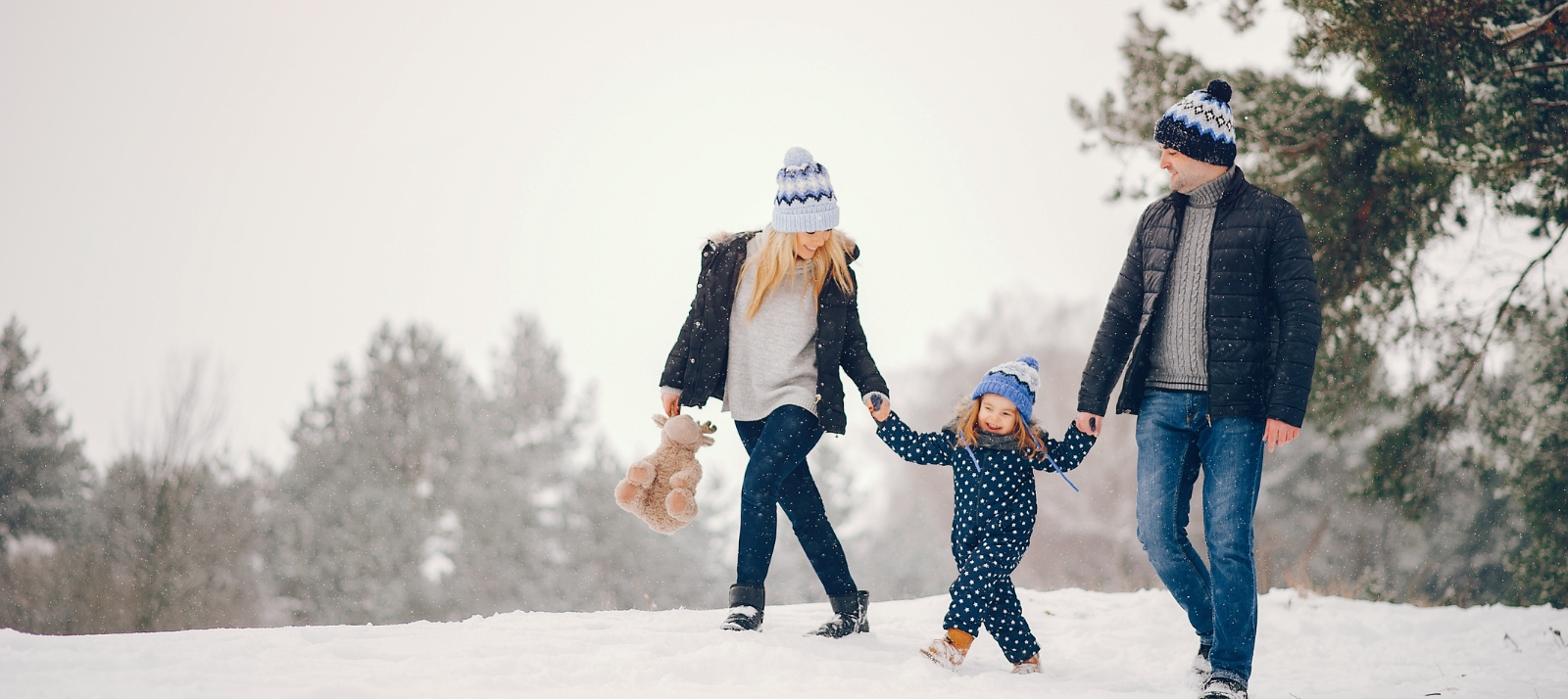 A family walks through a snowy trail.