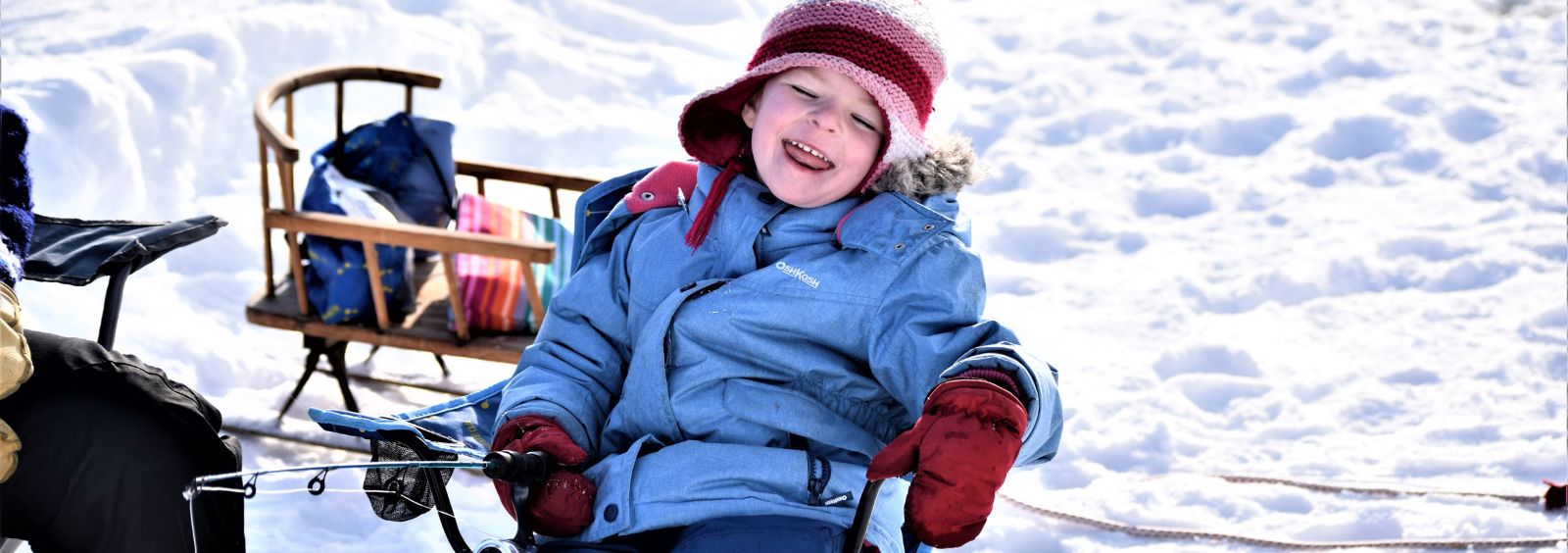 A young child laughing while ice fishing on the Ottawa River.
