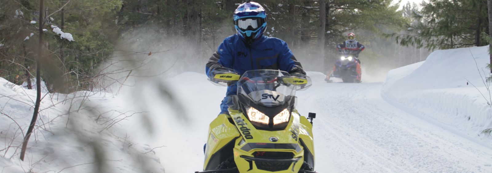A snowmobiler on an outdoor trail during winter.