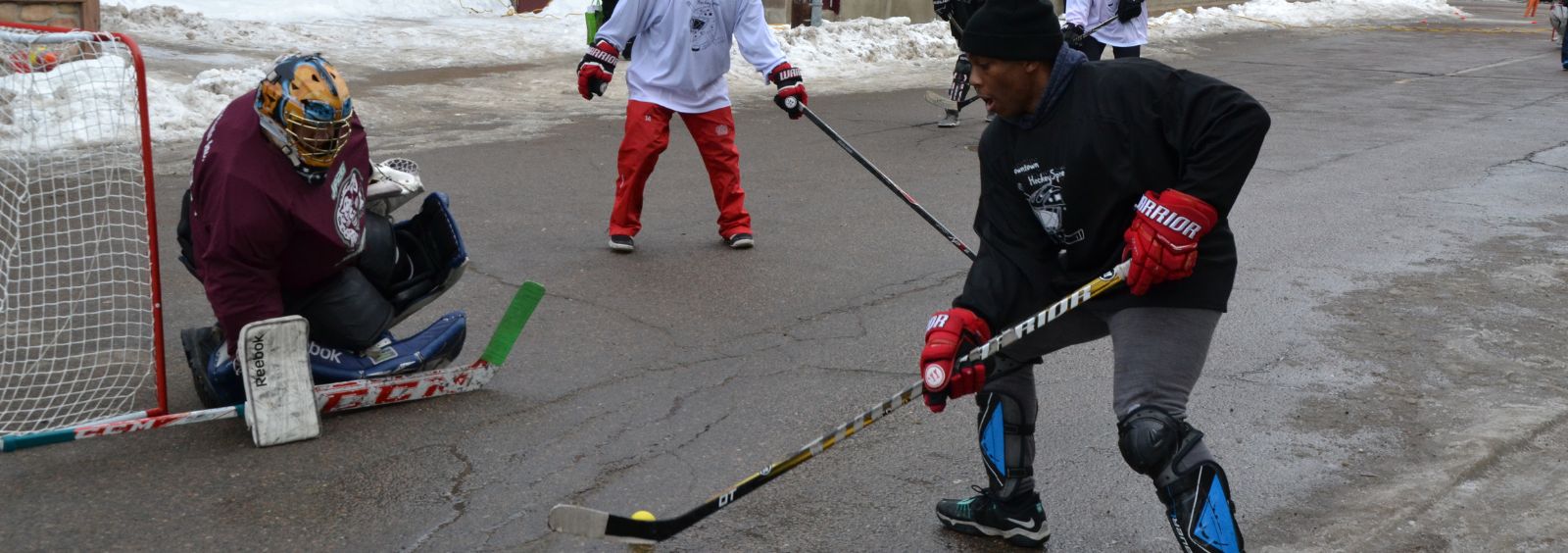 Youth playing road hockey in winter.