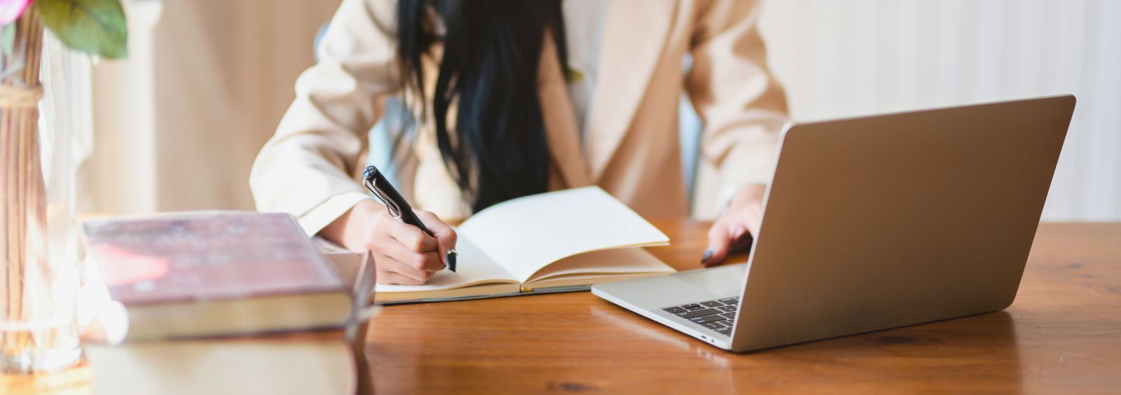 A person taking notes at a laptop.