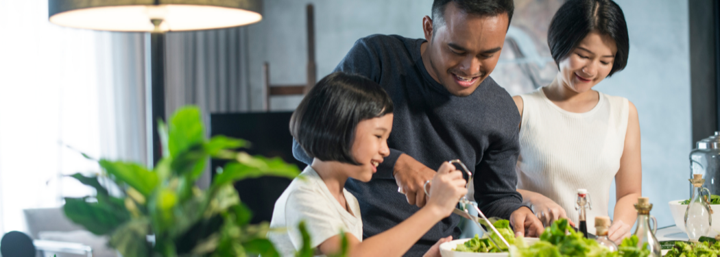 A family of four makes a meal.