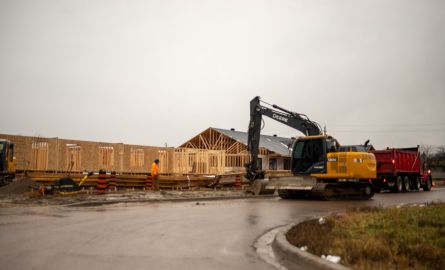 Construction equipment in front of a new house.