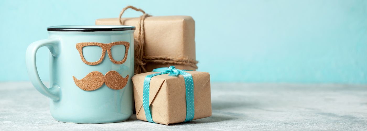 A blue mug next to wrapped presents.