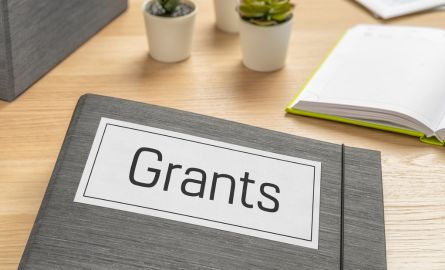 A folder that says grants on a desk.