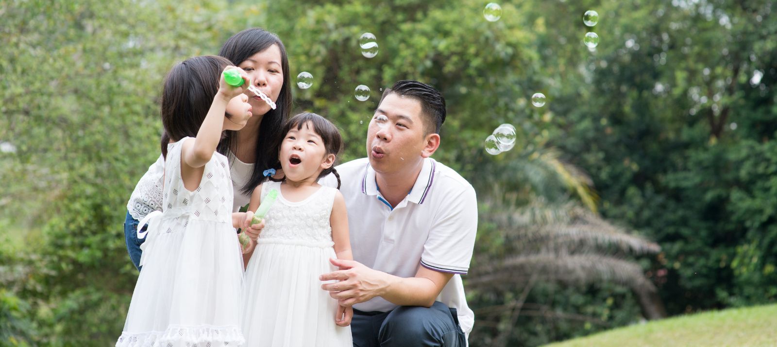 A family blowing bubbles outside.