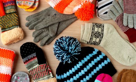A set of winter clothing including hats, scarves, and mittens.