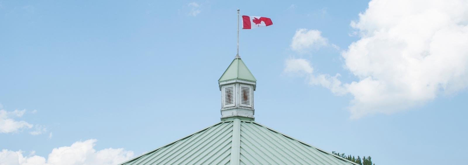 Canadian flag waving at the top of the Riverwalk Amphitheatre.