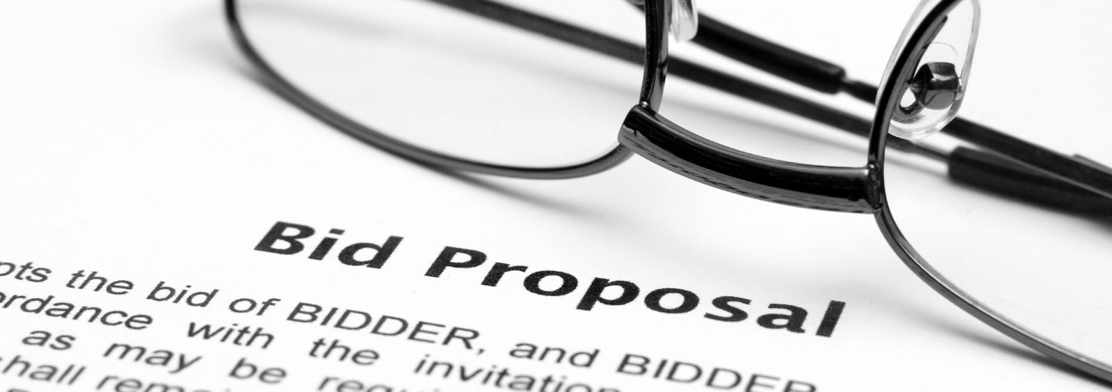 Bid proposal document with glasses on top.