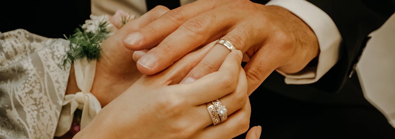 The hands of a husband and wife on their wedding day.