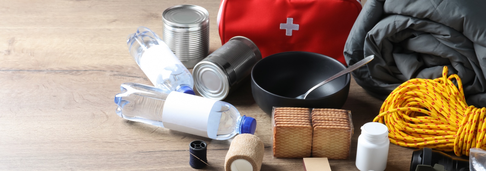 An emergency preparedness kit including water, a sleeping bag, flashlight, and first aid kit.