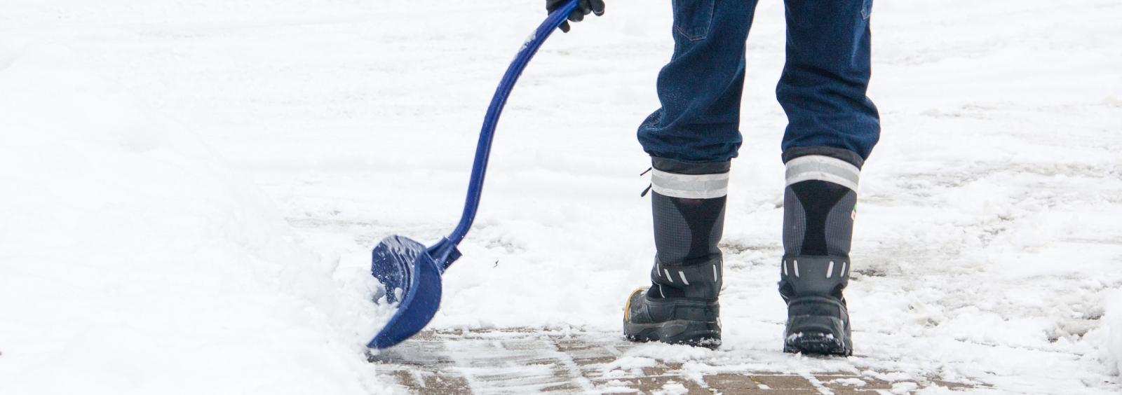 Person shoveling snow in a driveway.