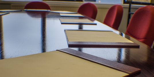 A set of chairs inside a boardroom.