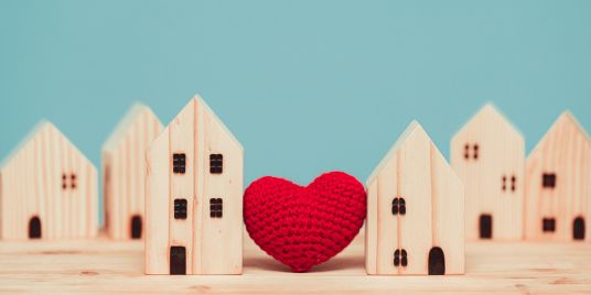 Houses made of wooden blocks with a red heart in the middle.