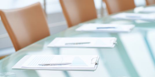 Empty chairs around a board table.