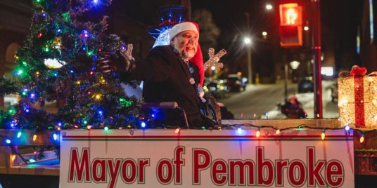 A man in a Santa hat on a parade float.