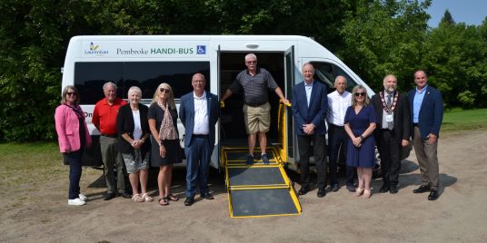 A group of people in front of a passenger van.