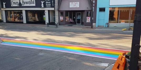 A rainbow crosswalk on a main street.