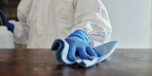 A gloved hand wiping a surface.