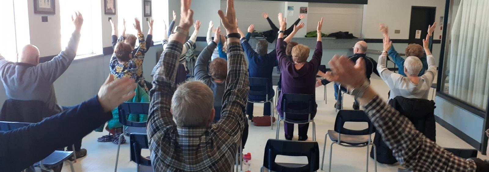 Seniors enjoying chair yoga at the PMC.