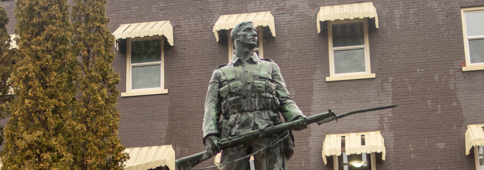 A statue of a soldier holding a gun at a war memorial.