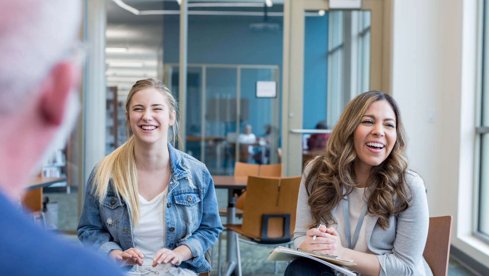 A pair of women smiling during a meeting.