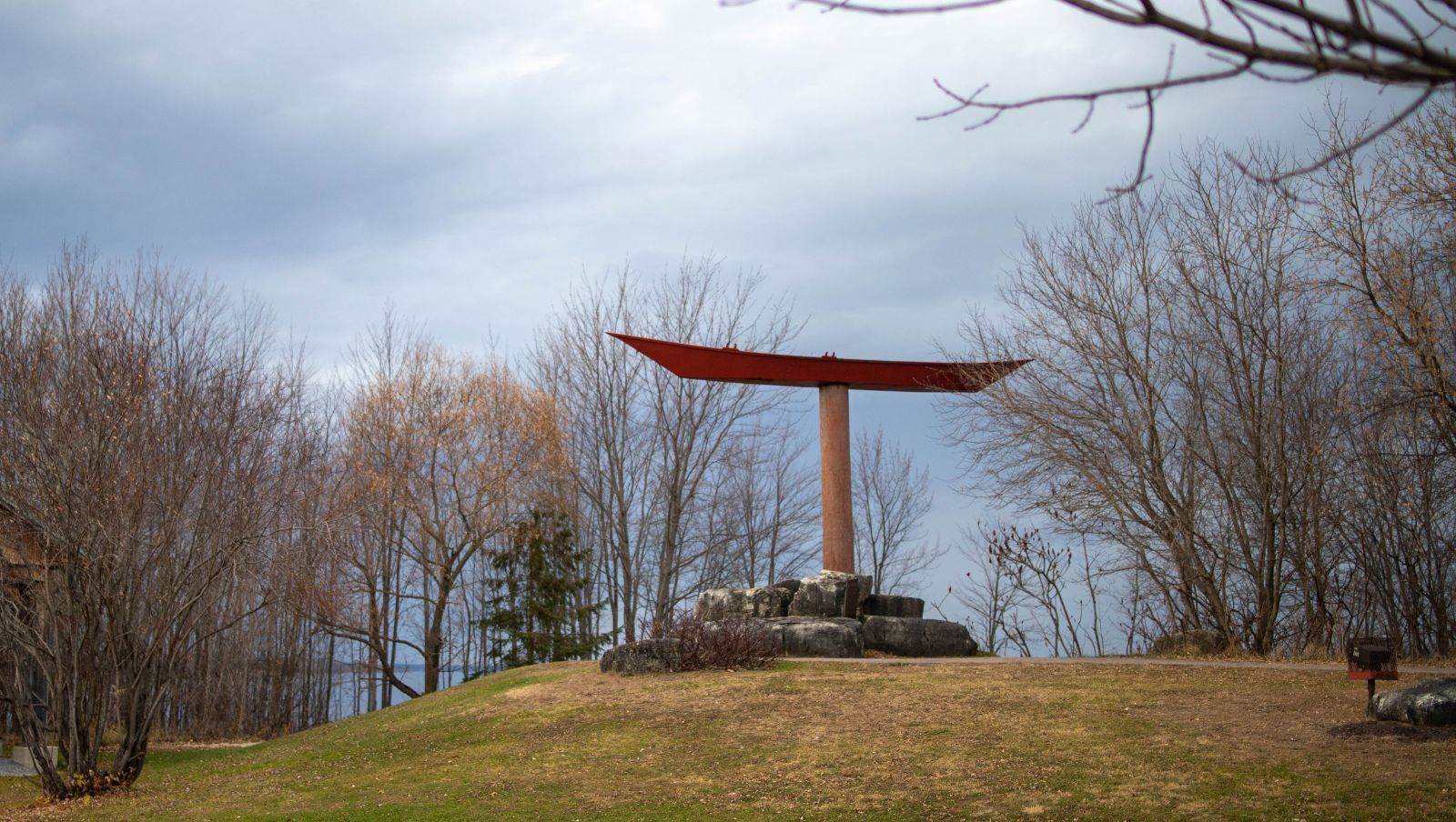 The Pembroke Waterfront. The Pointer Boat Monument sits in front of trees in autumn.