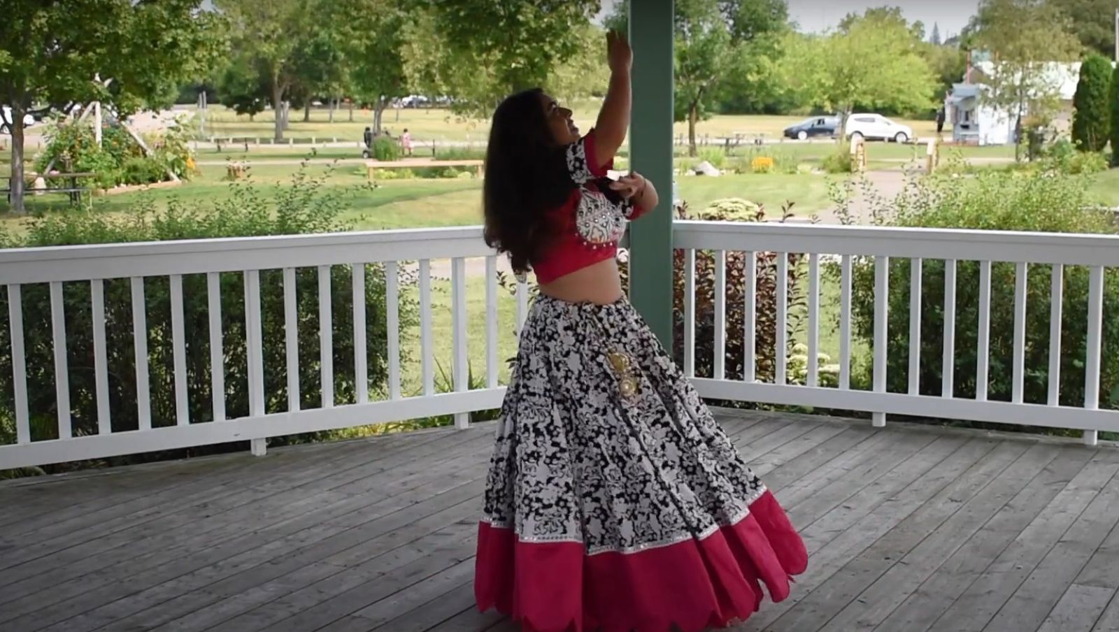 A woman dancing on an outdoor stage.