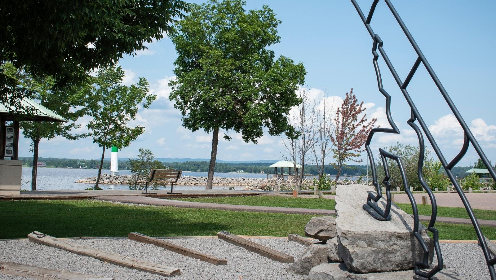 The Pembroke Waterfront. A sundial overlooks a boardwalk, which sits in front of the Ottawa River.
