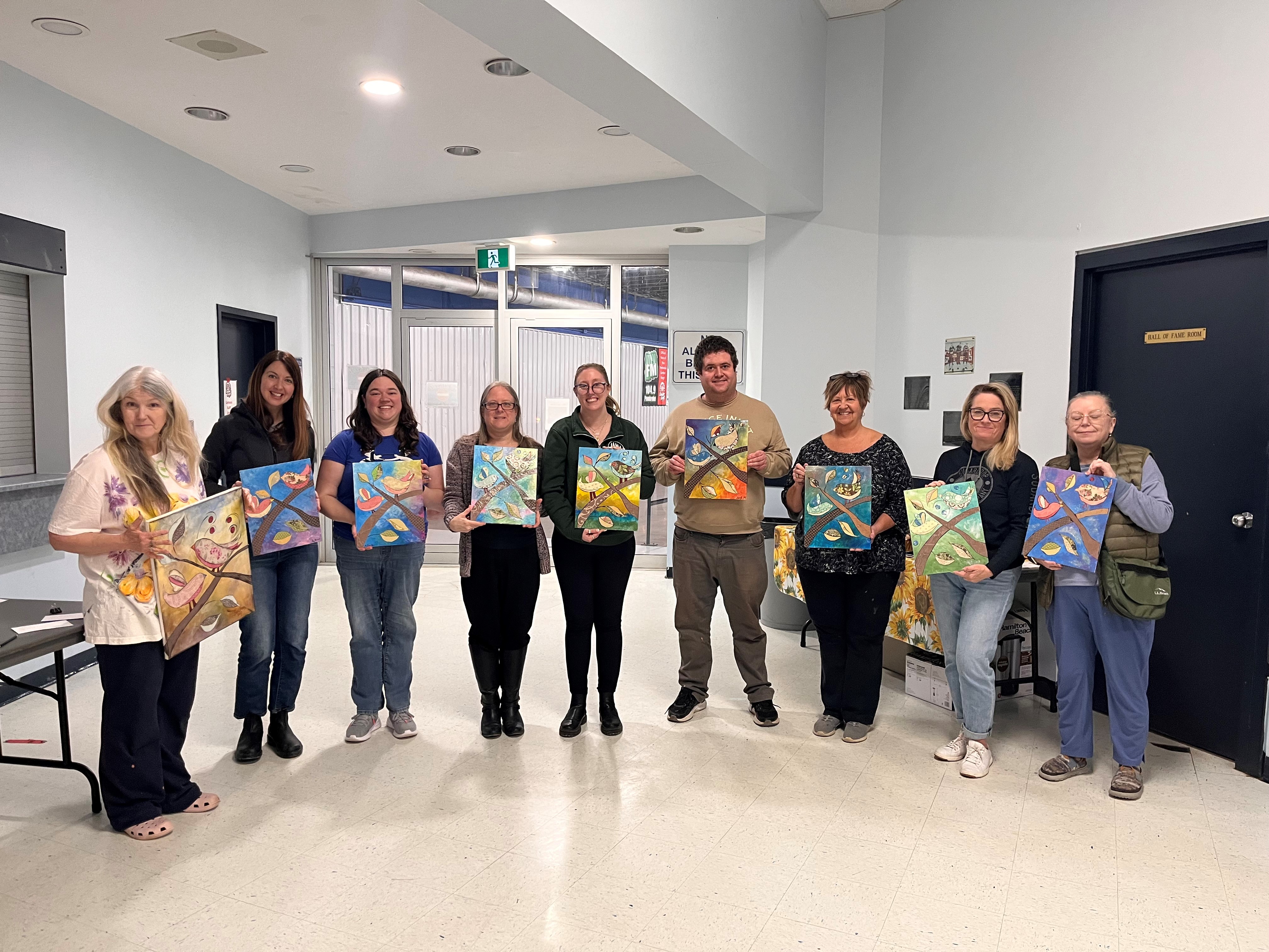 Mixed media class standing together holding there artwork up